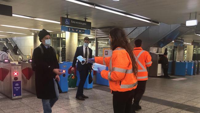 Complimentary masks are handed to commuters at Parramatta train station.