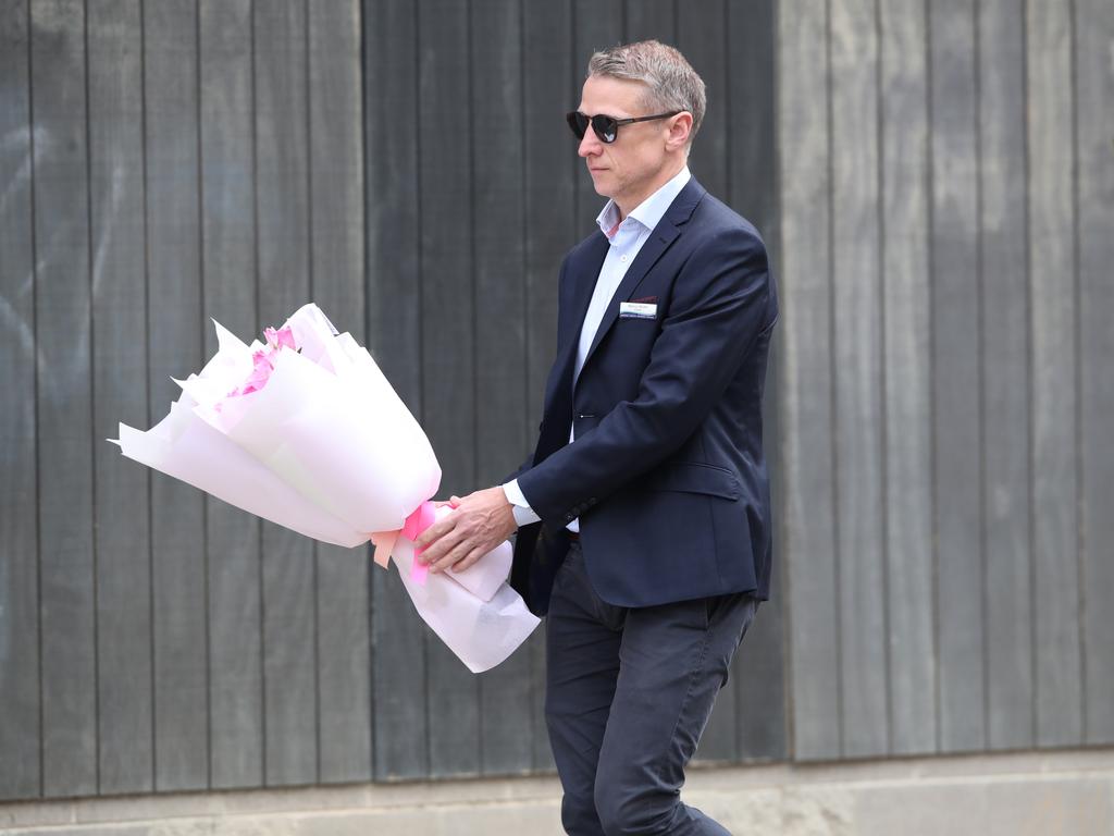 Principal Marcus Wicher leaves flowers after the tragedy. Picture: David Crosling