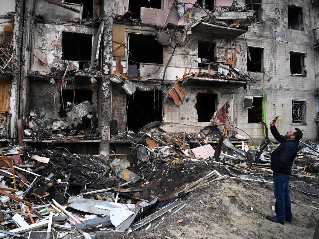 A man takes pictures of a damaged residential building at Koshytsa Street, a suburb of the Ukrainian capital Kyiv. Picture: Daniel Leal / AFP)