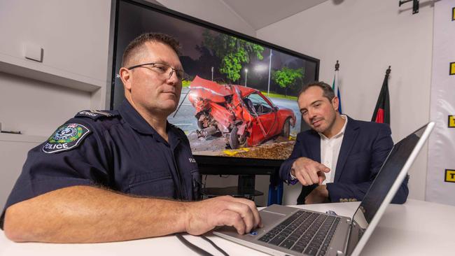 Brevet Sergeant Jason Thiele with Ben, showing him images of the crash scene. Picture: Ben Clark