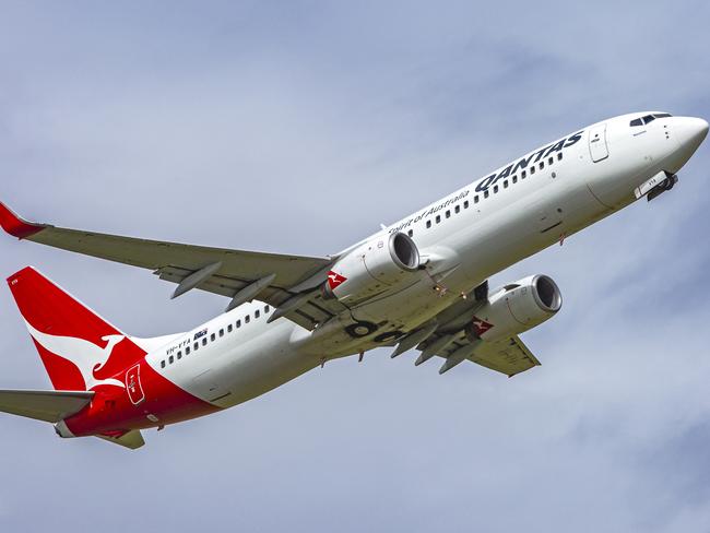 Adelaide, Australia - Oct 16, 2016: Qantas VH-VYA Boeing 737-838 "Narooma" takes to the air from Adelaide Airport with a backdrop of wispy white cloud. The main landing gear has retracted with the front wheel still slightly down.