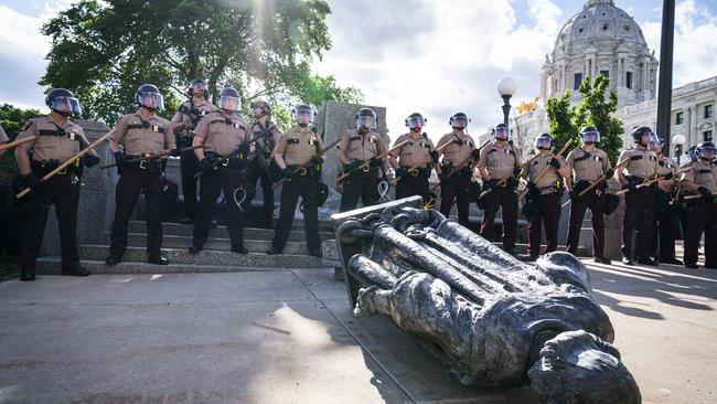 Minnesota State Troopers surround the statue of Christopher Columbus after it was toppled in front of the Minnesota State Capitol. Picture: Leila Navidi/Star Tribune