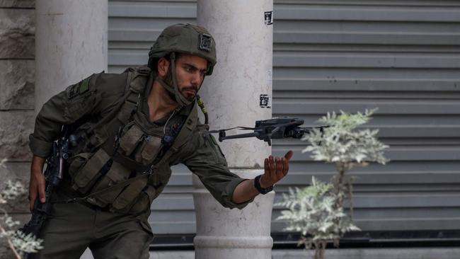 An Israeli soldier flies a small drone. (Photo by JAAFAR ASHTIYEH / AFP)