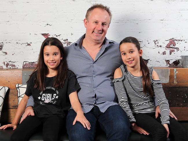 Holly, 10, Jay and Amelia, 10,  Walkerden posing at Nova, Brisbane 12th of August 2019.  Jay hosts a real life podcast with his daughters about his uncle who disappeared he was 38.   (AAP Image/Josh Woning)