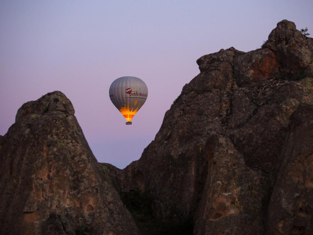 A hot air balloon is seen over rock formations on April 18, 2016 in Nevsehir, Cappadocia, Turkey. Picture: Getty