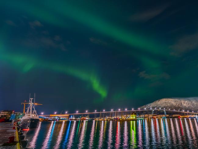 Insight Astronomy Photographer of the Year 2017 shortlist selection: Beautiful Trømso . Picture: Derek Burdeny (USA) The aurora activity forecast was low for this evening, so the photographer remained in Tromsø rather than driving to the fjord. The unwitting photographer captured Nature’s answer to a stunning firework display as the Northern Lights dance above a rainbow cast in the waters of the harbour in Trømso made for a spectacular display, but did not realize what he had shot until six months later when reviewing his images. Tromsø, Norway, 7 March 2016