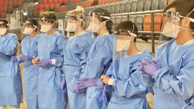 Health workers dressed in PPE ready to test Territorians at the Marrara netball stadium this morning. Picture: Gary Shipway