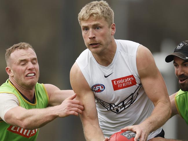 MELBOURNE, AUSTRALIA - SEPTEMBER 20: Billy Frampton of the Magpies is tackled by Tom Mitchell (L) and Steele Sidebottom of the Magpies during a Collingwood Magpies AFL training session at Olympic Park Oval on September 20, 2023 in Melbourne, Australia. (Photo by Daniel Pockett/Getty Images)