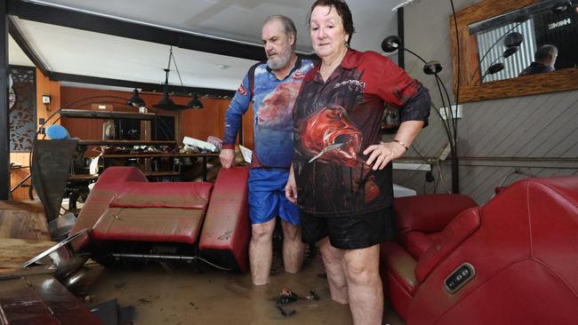 A monsoonal tropical low pressure system has brought devastating widespread flooding to North Queensland and parts of Far North Queensland, with over 1000 millimetres of rain recorded in some areas. Clitheroe Street residents David and Tracy Ebert lookfor items to salvage from the lounge room, after flood water inundated their Cardwell home overnight. Picture: Brendan Radke