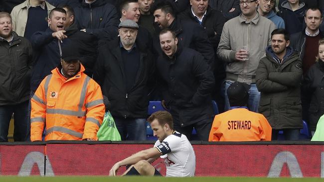Tottenham's Harry Kane sits on the pitch in front of Millwall supporters after getting injured.