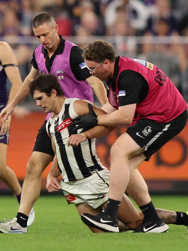 Schulz is helped to his feet by trainers.