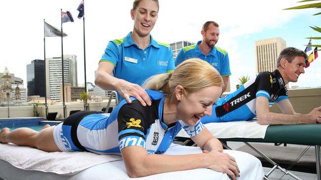 Beat Cancer Tour participants Felicity Lloyd and John Cullen get a post-training massage from Australian Institute of Fitness massage therapist Kim Bailey on the pool deck at the Hilton Adelaide, while BCT training team captain Darren Fidge watches on. Picture: Stephen Laffer