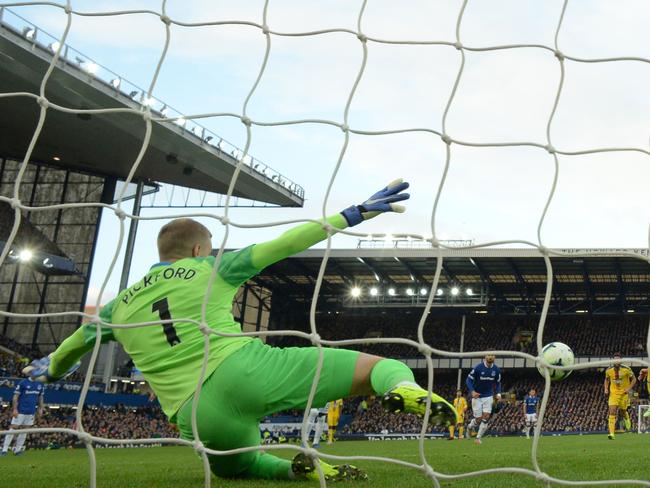 Everton's English goalkeeper Jordan Pickford (L) sticks out a leg to save this penalty from Crystal Palace's Serbian midfielder Luka Milivojevic (R) during the English Premier League football match between Everton and Crystal Palace at Goodison Park in Liverpool, north west England on October 21, 2018. - Everton won the game 2-0. (Photo by Oli SCARFF / AFP) / RESTRICTED TO EDITORIAL USE. No use with unauthorized audio, video, data, fixture lists, club/league logos or 'live' services. Online in-match use limited to 120 images. An additional 40 images may be used in extra time. No video emulation. Social media in-match use limited to 120 images. An additional 40 images may be used in extra time. No use in betting publications, games or single club/league/player publications. /