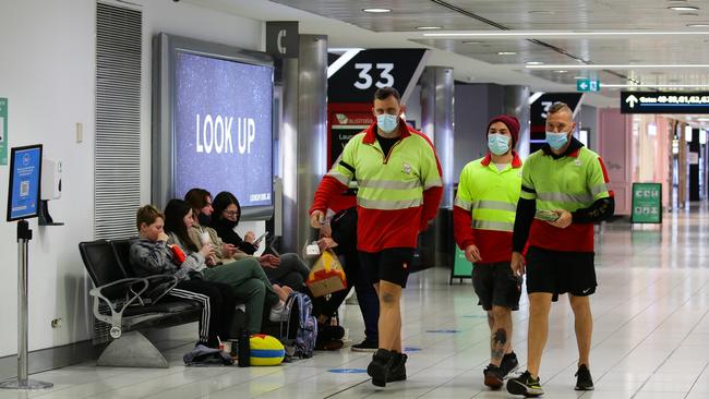 Workers in face masks walking through the Domestic Airport Terminal at Sydney Airport. Picture: NCA NewsWire / Gaye Gerard