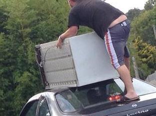 A New Zealand man balances a fridge on top of a car. Source: Facebook, NewLynnCommunity.