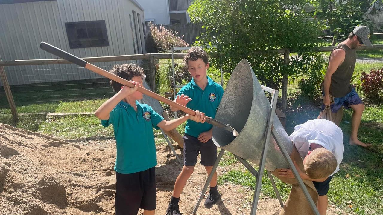 Austin and Ethan Smith have helped their mum Lisa fill up bags of sand to prevent water from entering their business Kevla Espresso and Health Food Bar in Queens Beach in Bowen, which is located in a red zone for flooding. Picture: Estelle Sanchez