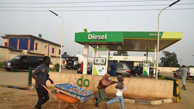 A vendor pushes wheelbarrow past a filling station dispensing diesel to motorists at Warewa, along Lagos Ibadan expressway, Ogun State, southwest Nigeria. Picture: AFP