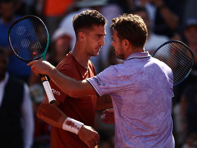 Australia's Thanasi Kokkinakis (L) comforts Switzerland's Stan Wawrinka after his victory. Picture: AFP