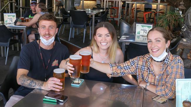 Leon Forrest, Tyler Beamand and Robyn Coburn cheer to the end of Darwin's 72 hour lock down ends at The Tap Bar on Mitchell St. Picture: Glenn Campbell