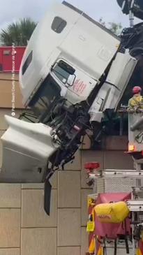 Dramatic moment firefighters rescue driver dangling off overpass