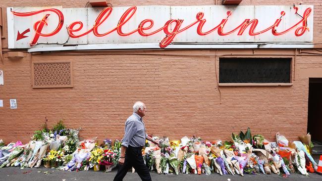 Sisto Malaspina’s business partner Nino Pangrazio walks past floral tributes at their eatery. Picture: Michael Dodge/Getty Images