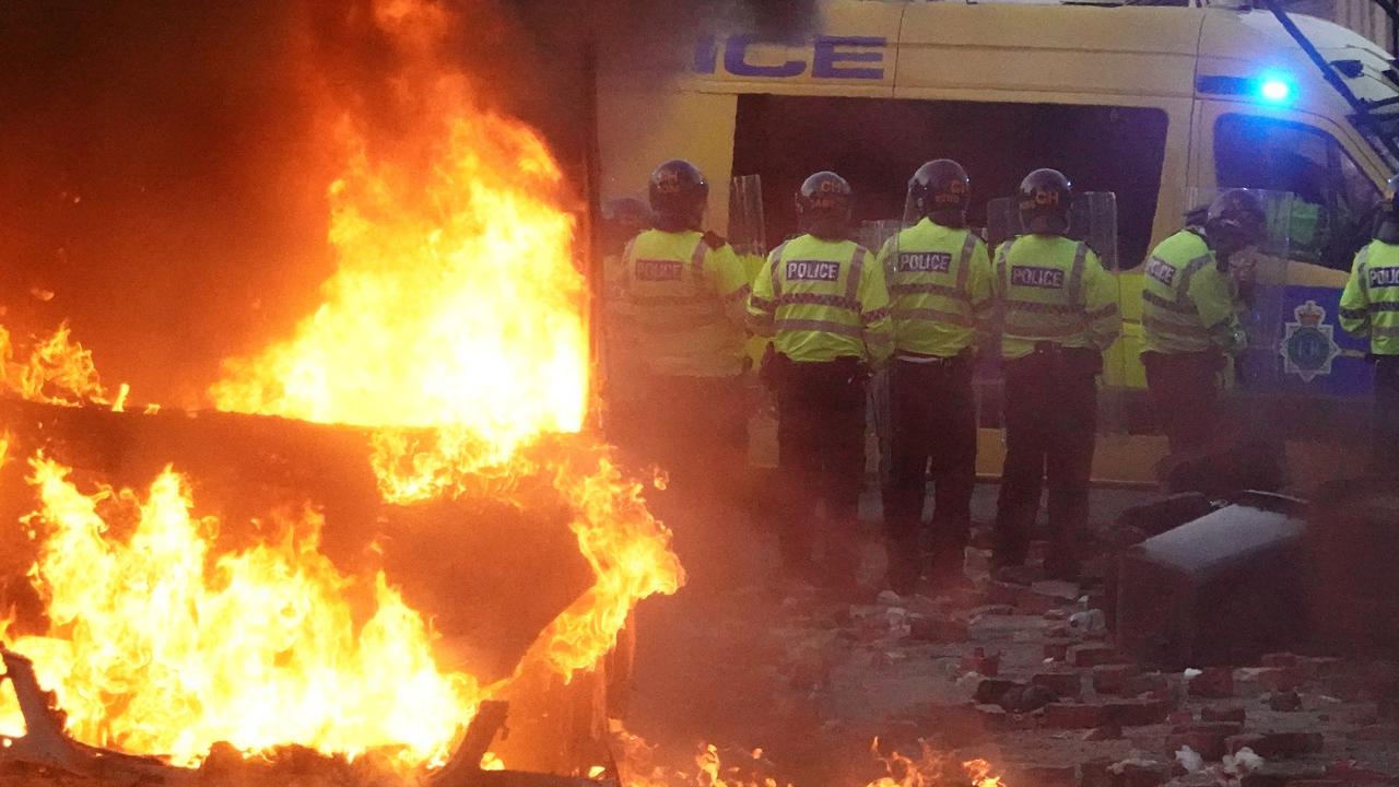 Riot police hold back protesters near a burning police vehicle after disorder broke out on July 30, 2024 in Southport, England. (Photo by Getty Images)