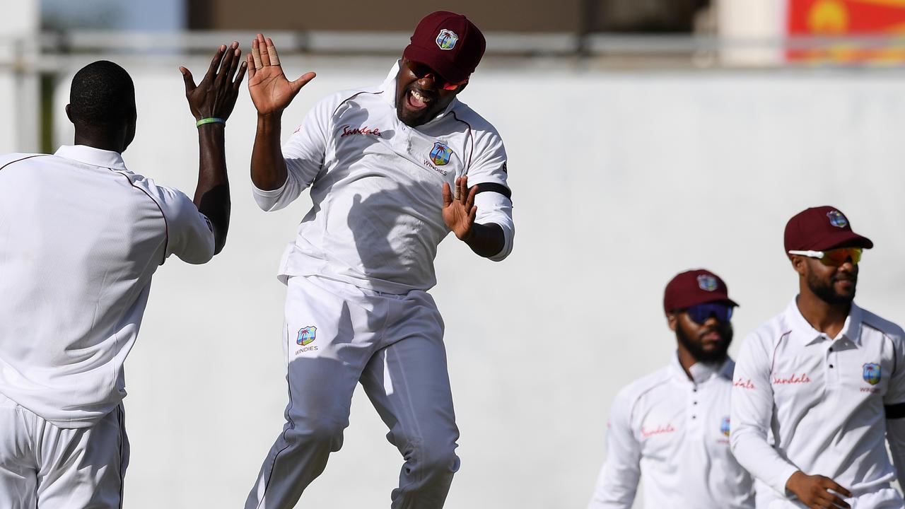 Darren Bravo of West Indies congratulates captain Jason Holder after the wicket of Jos Buttler as West Indies crush England in the second Test. (Photo by Shaun Botterill/Getty Images,)