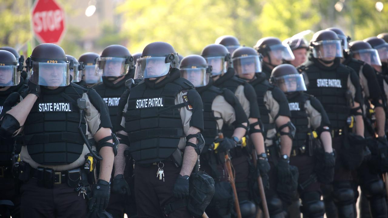 Law enforcement officers watch on as people protest for the third straight day following the death of George Floyd. Picture: AFP