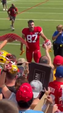 Travis Kelce gives gloves to young fan wearing Swiftie-themed t-shirt