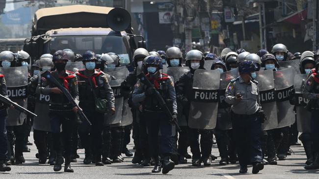 Riot police advance to clear protesters in Yangon on Friday. Picture: AFP