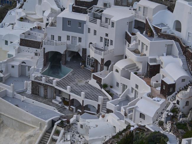 An empty swimming pool is seen in a group of clifftop buildings in the town of Oia on the earthquake-struck island of Santorini, Greece. Picture: AP