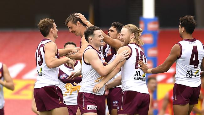 Teammates mob Joe Daniher after his first goal as a Lion.