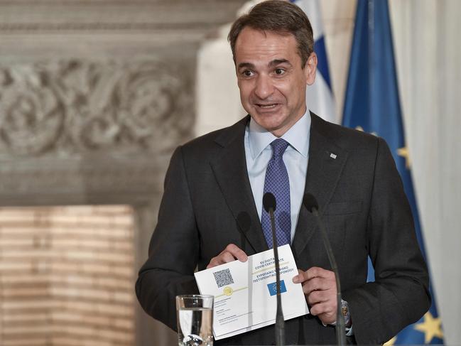 Greece's Prime Minister Kyriakos Mitsotakis shows the proposed EU digital Covid Certificate during a joint statement to the press with the European Council President. Picture: AFP