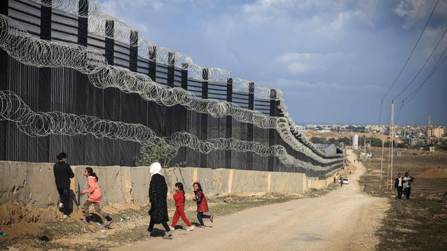 Displaced Palestinians walk along the Philadelphi, or Salaheddin corridor, a narrow buffer zone along the Gaza Strip's border with Egypt. Picture: Mahmud Hams/AFP