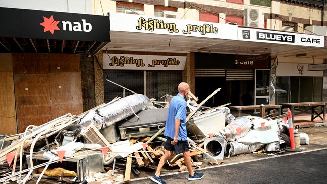 A man walks past a pile of debris awaiting collection in the CBD on March 29, 2022. Picture: Dan Peled/Getty Images