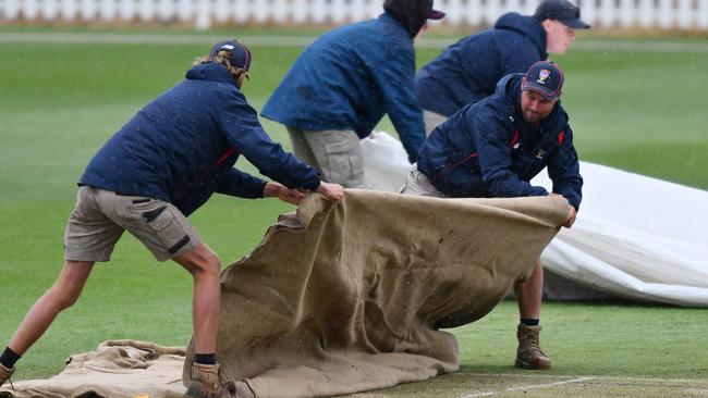 Groundsman rush the cover on due to rain during the Women's Big Bash League match between the Sydney Thunder and the Perth Scorchers at Karen Rolton Oval, on November 11, 2021, in Adelaide, Australia. (Photo by Mark Brake/Getty Images)