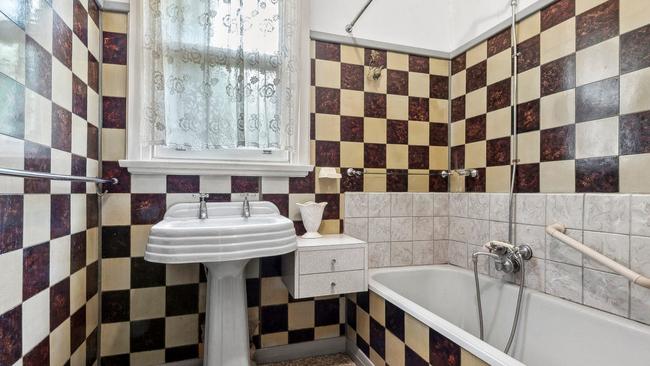 The striking colour scheme and pedestal basin remains in the bathroom.