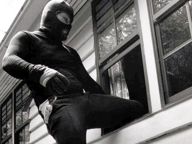 House breaking demo. Burglar climbing through a window of a house Crime prevention robbery break enter home invasion robber attempted security burglary balaclava wheelie bin file pic nov 1989 35/Q/6343 generic situation