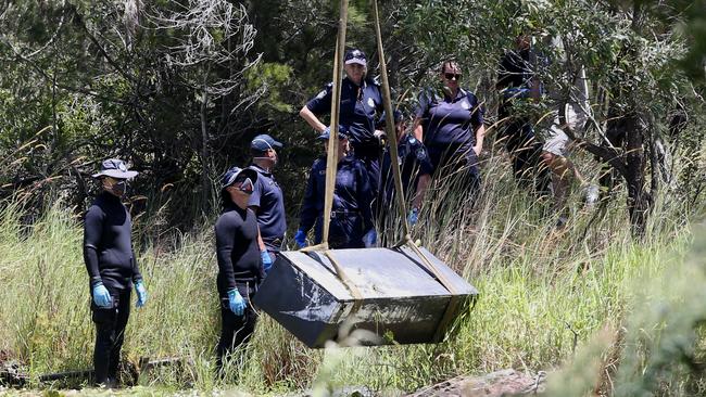 Police retrieve the toolbox from a dam near Scrubby Creek in Kingston Picture: Jono Searle