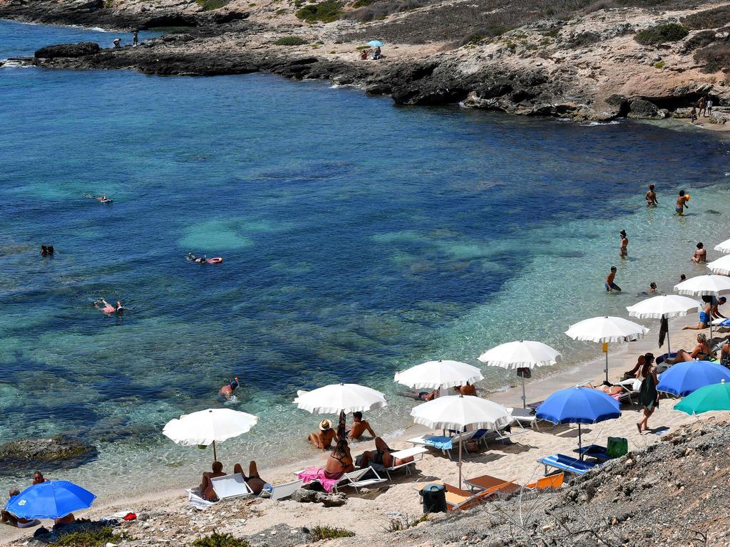 People sunbath on a beach in the Italian Pelagie Island of Lampedusa. Picture: Alberto PIZZOLI / AFP