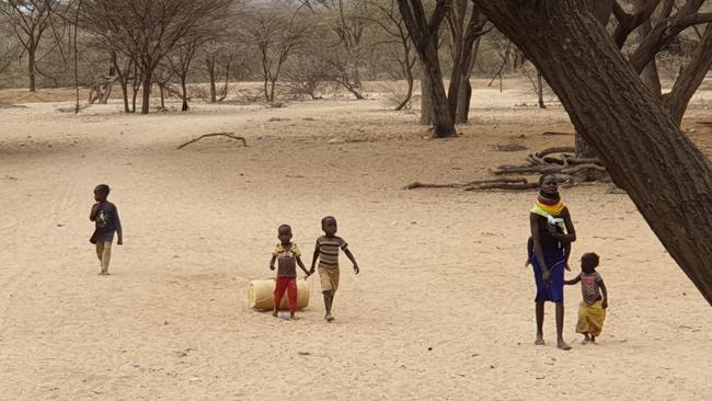 Children roll empty barrels along a dry river-bed to get water from a community water bore in Turkana County, Kenya, which is suffering the worst drought in 40 years. Picture: Ellen Whinnett