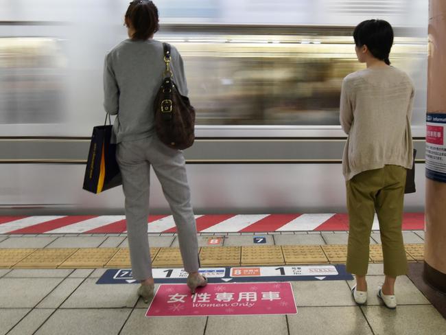 Women wait to board a women's-only carriage onboard a train on a subway station platform in Tokyo on June 2, 2017.  In Japan, where train travel can often be a perilous ordeal for women, an insurance company is reporting a sudden run on a policy that protects men falsely accused of groping. / AFP PHOTO / Kazuhiro NOGI