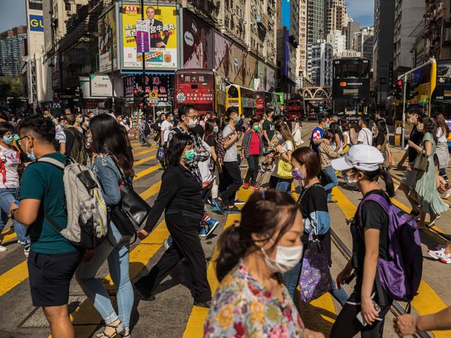 People wearing face masks as a preventive measure against the COVID-19 coronavirus cross a street in the Causeway Bay shopping district in Hong Kong. Picture: AFP