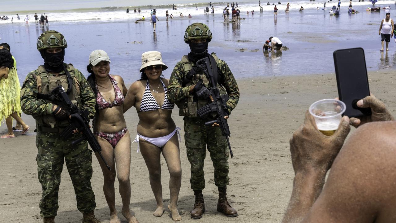 Two revellers pose for photos with soldiers. Picture: John Moore/Getty Images