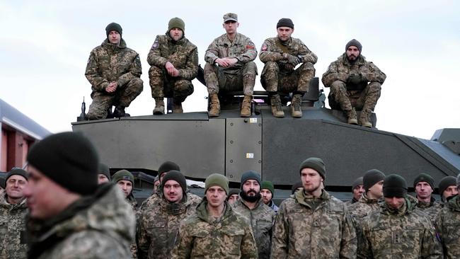 Soldiers gather as Ukraine's President Volodymyr Zelensky and Britain's Prime Minister Rishi Sunak meet Ukrainian troops being trained to command Challenger 2 tanks. Picture: AFP.