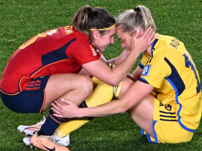 Sweden's forward #18 Fridolina Rolfo (R) is consoled by Spain's forward #08 Mariona Caldentey at the end of the Australia and New Zealand 2023 Women's World Cup semi-final football match between Spain and Sweden at Eden Park in Auckland on August 15, 2023. (Photo by Saeed KHAN / AFP)