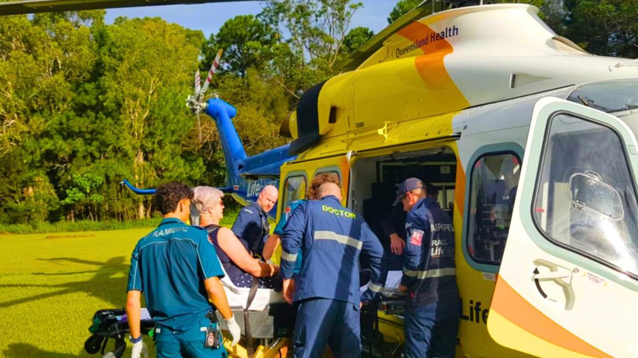 Paramedics load Kaye Scoble into a helicopter on Macleay Island after she had a medical emergency with the ambulance forced to drive along a bumpy dirt track to get to the helipad. Picture: Contributed