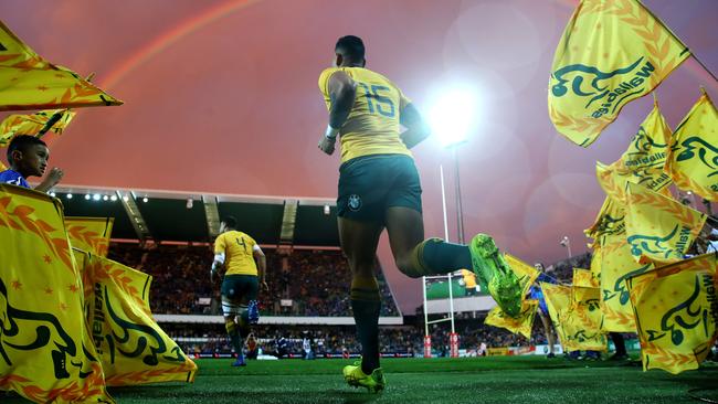 Israel Folau runs onto the ground under a rainbow. Picture: Cameron Spencer/Getty Images