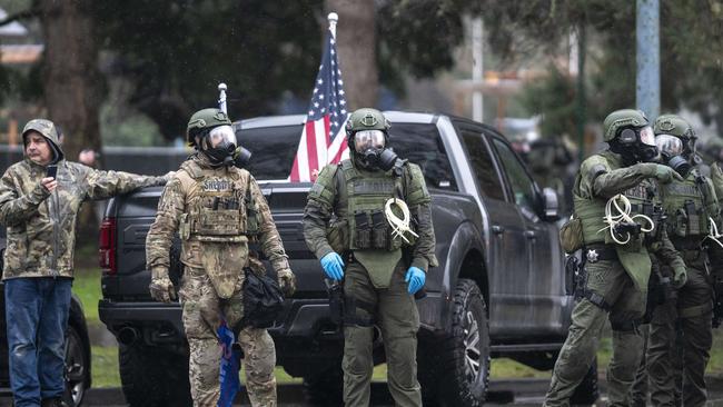 A supporter of President Trump (far left) stands with a line of Oregon State Troopers on January 6 last year. Picture: AFP