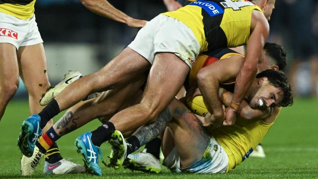 ADELAIDE, AUSTRALIA - JUNE 06:  Lachlan Murphy of the Crows  tackled by  Jack Graham  and  Tim Taranto of the Tigers  during the round 13 AFL match between Adelaide Crows and Richmond Tigers at Adelaide Oval, on June 06, 2024, in Adelaide, Australia. (Photo by Mark Brake/Getty Images)